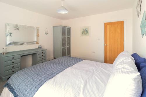 a bedroom with a bed and a dresser and a mirror at Lovely 2- Bedroom Apartment with Stunning Sea Views in Worthing
