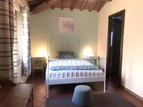 um quarto com uma cama branca num quarto em La Casa Lemuria - Süd-Toscana em Zancona
