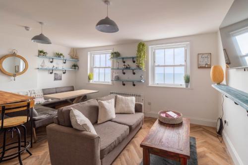 a living room with a couch and a table at Lovely 2- Bedroom Apartment with Stunning Sea Views in Worthing