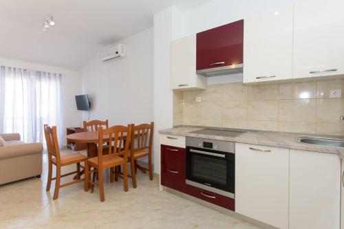 cocina y comedor con mesa y sillas en Apartments Betanija, en Trogir