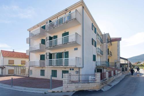un edificio blanco alto con balcones en una calle en Apartments Betanija, en Trogir