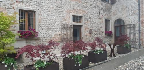 a building with potted plants on the side of it at La Locanda della Torre "Foresteria Lombarda" in Marne di Filago