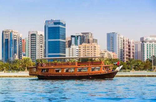 un barco en el agua frente a una ciudad en Abu Dhabi Centre - Unique Room, en Abu Dabi