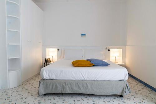 a bedroom with a bed with two pillows on it at Cala Moresca Apartments in Bacoli