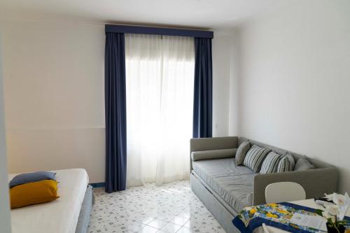 a living room with a couch and a window at Cala Moresca Apartments in Bacoli