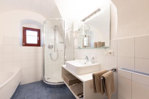 a white bathroom with a sink and a shower at Chalet Ansitz Pastreinbach in Appiano sulla Strada del Vino
