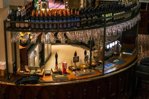 a bar with a bunch of trophies and a chandelier at The Old Mill in Coxhoe