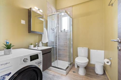 La salle de bains est pourvue de toilettes, d'une douche et d'un lave-linge. dans l'établissement Chania Elite Home III-Elegant Studio 4Km From Center, à La Canée