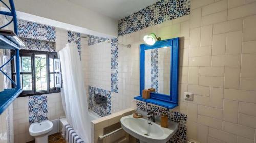 een badkamer met een wastafel, een toilet en een raam bij Casa Rural Viña Meneses in Marchena