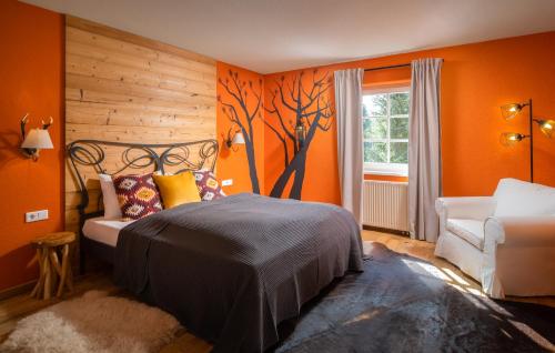 a bedroom with orange walls and a bed with a tree mural at Landhotel Altes Zollhaus in Hermsdorf
