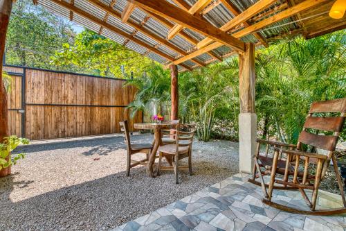 a patio with a table and chairs under a wooden pergola at Hotel Villas Tangerine in Sámara