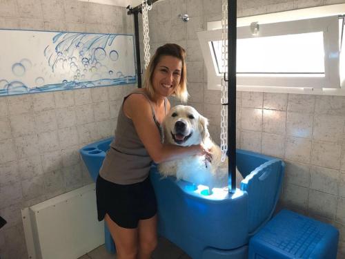 羅莎皮內塔的住宿－AdriaCamp Mobile Homes Rosepineta，把狗放在浴缸里的女人