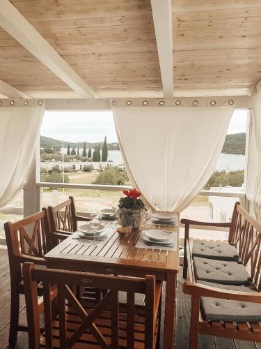 a dining room with a table and chairs with a view at Mobile Home Aloha in Tisno