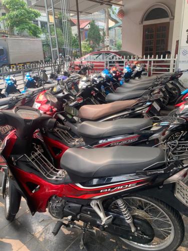 a row of motorcycles parked in a parking lot at Ngan Ha Homestay in Ha Giang