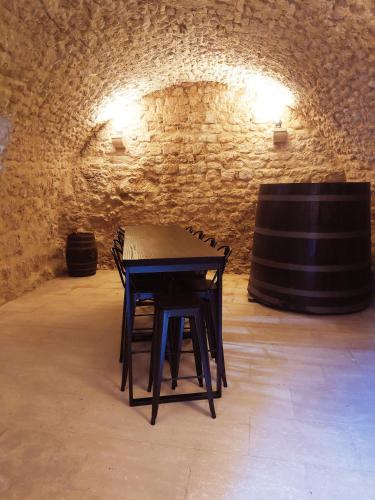 a table in a wine cellar with two barrels at La Closerie D'Escalin gîte 12 personnes et Jacuzzi in La Garde-Adhémar