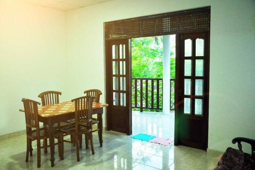 a dining room with a table and chairs and an open door at Sunil Homestay in Tangalle