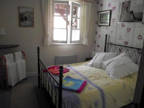 een slaapkamer met een groot bed en een raam bij Vue du Pont in Entraygues-sur-Truyère