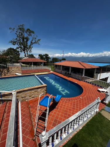 a large swimming pool with a red bricknergynergynergynergynergynergyhewshews at Finca Vacacional Guanani in Socorro