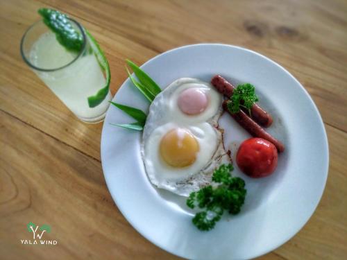 a plate of food with eggs and broccoli on a table at Yala wind in Tissamaharama