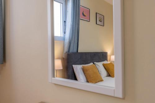 espejo reflejo de una cama en una habitación en Scarlett City Apartment, en Zakynthos