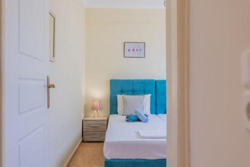a bed with a blue headboard in a bedroom at Scarlett City Apartment in Zakynthos