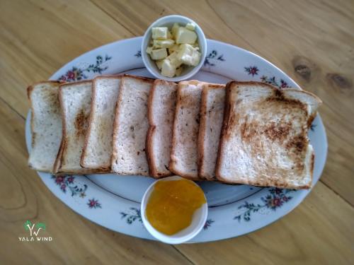 a plate with a grilled sandwich and a bowl of butter at Yala wind in Tissamaharama