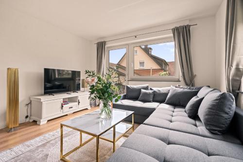 ein Wohnzimmer mit einem Sofa und einem TV in der Unterkunft Ferien-Apartment Seehas mit Privatstrandzugang in Friedrichshafen