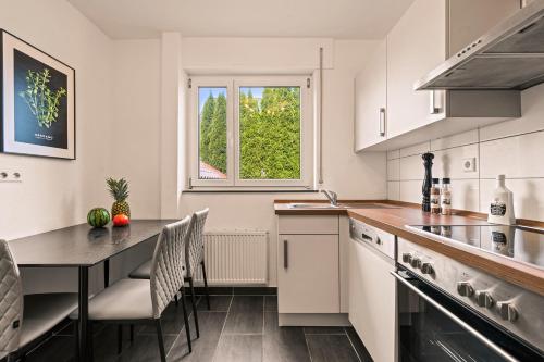 a kitchen with a table and chairs and a window at Ferien-Apartment Seehas - mit priv Strandzugang in Friedrichshafen