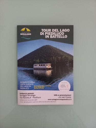 a poster of a boat on a river at Il Girasole del Lago in Piediluco