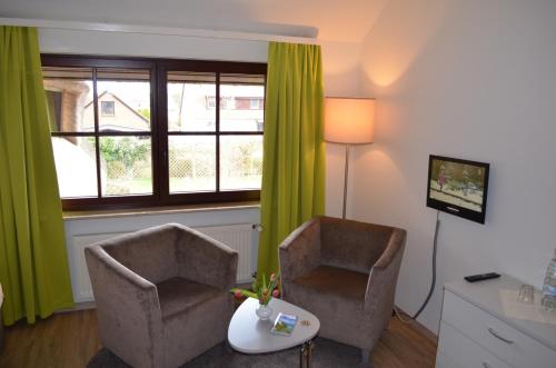 a living room with two chairs and a television at Mare Balticum Urlaub auf Rügen in Sagard