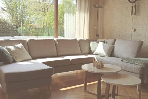 a living room with a couch and two tables at Mozaïkhuis in De Haan
