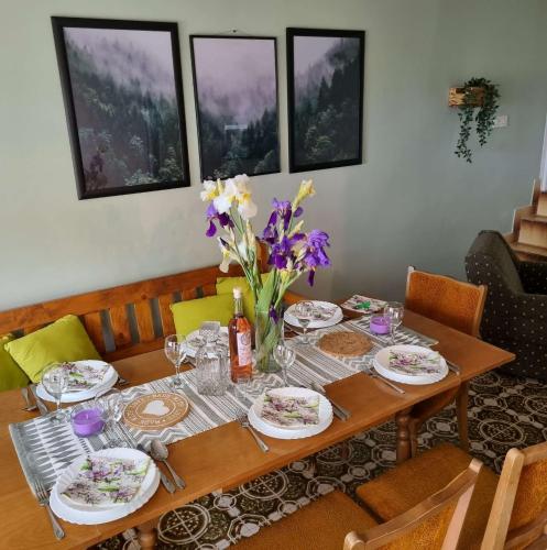 a wooden table with plates and flowers on it at Casa Horizont in Slankamenački Vinogradi