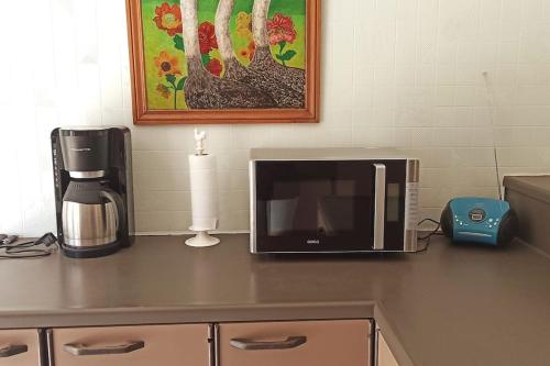a microwave sitting on a counter next to a coffee maker at Mozaïkhuis in De Haan