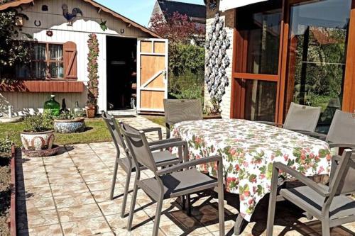 a patio with a table and chairs on a patio at Mozaïkhuis in De Haan