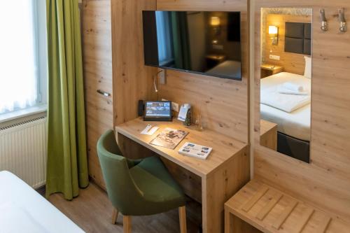 a hotel room with a desk and a bed at AKZENT Hotel Restaurant Roter Ochse Rhens bei Koblenz in Rhens