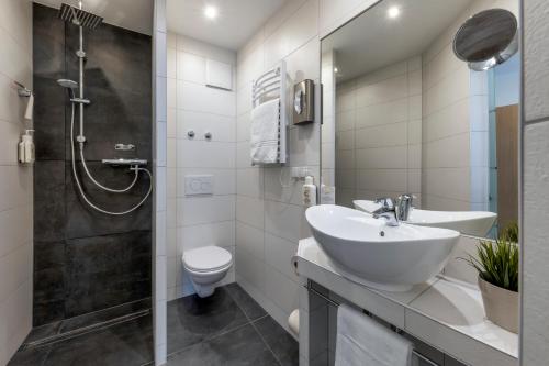 a bathroom with a sink and a toilet and a shower at AKZENT Hotel Restaurant Roter Ochse Rhens bei Koblenz in Rhens