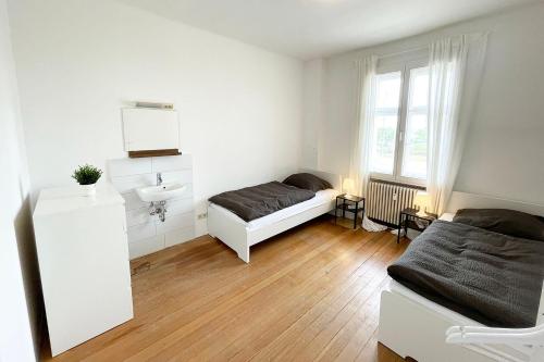 - une chambre avec un lit, un lavabo et un miroir dans l'établissement Apartment with balcony in Edingen-Neckarhausen, à Edingen-Neckarhausen