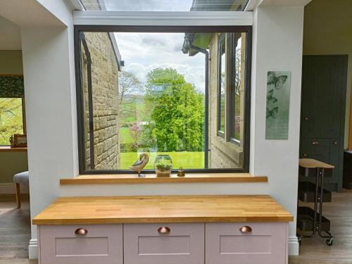 a large window in a room with a bench in front of it at Castleys in Skipton
