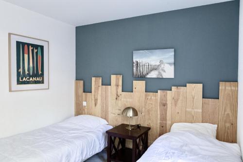 deux lits dans une chambre aux murs bleus dans l'établissement Belle villa familiale rénovée dans cadre exceptionnel-AG15, à Lacanau