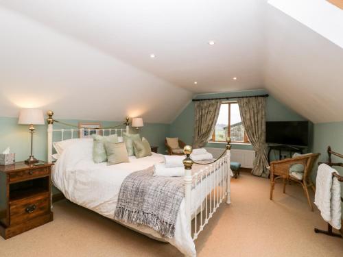 a bedroom with a large bed and a window at Little Stables Cottage in Blandford Forum