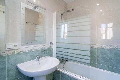 a white bathroom with a sink and a bath tub at Adosado con vistas al mar desde la piscina con BBQ in Vélez-Málaga
