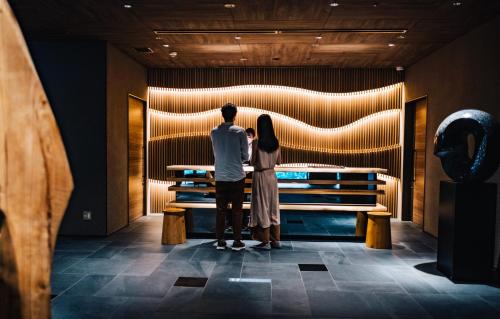 a man and woman looking at a display in a museum at Hotel Resol Trinity Osaka in Osaka