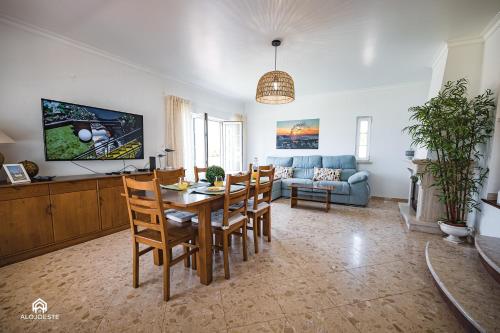 a living room with a table and chairs and a couch at Villa Castelo de Mar in Ericeira