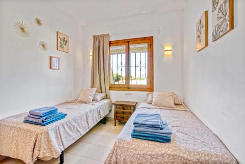 a bedroom with two beds and a window at Amor Supremo in Cumbre del Sol