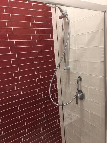 a shower in a bathroom with a red brick wall at MH Design Hotel in Naples