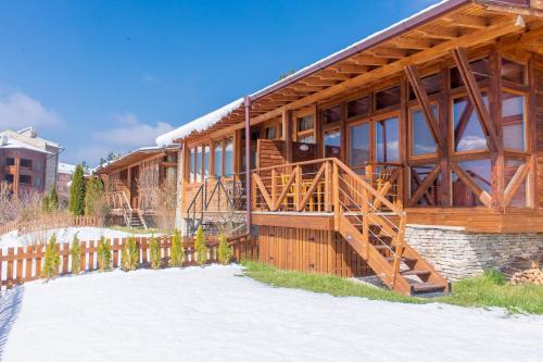 a large wooden house with a wooden staircase in front at Katarino SPA Hotel in Bansko