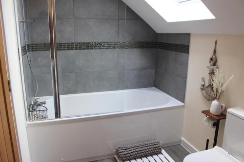 a bathroom with a shower with a bath tub at No 1 The Paddock in Bude