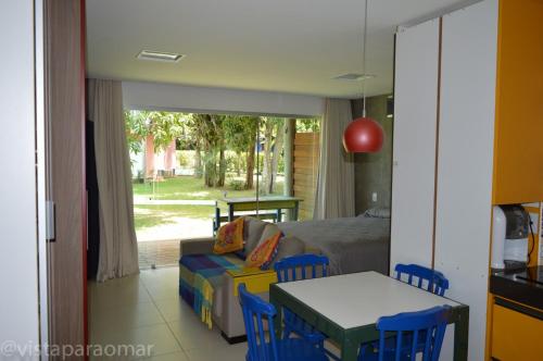 uma sala de estar com um sofá, uma mesa e uma cama em Studio Luxo Ecológico. em Maceió
