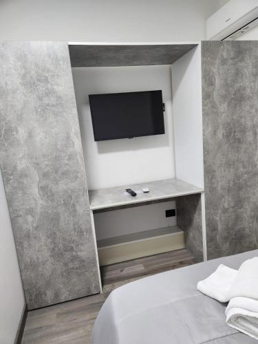 a bedroom with a bed and a tv on a wall at Albergo 3 Torri in Maddaloni