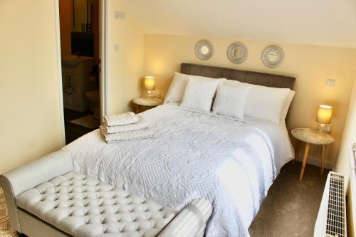 a bedroom with a large white bed and two tables at No 1 The Paddock in Bude